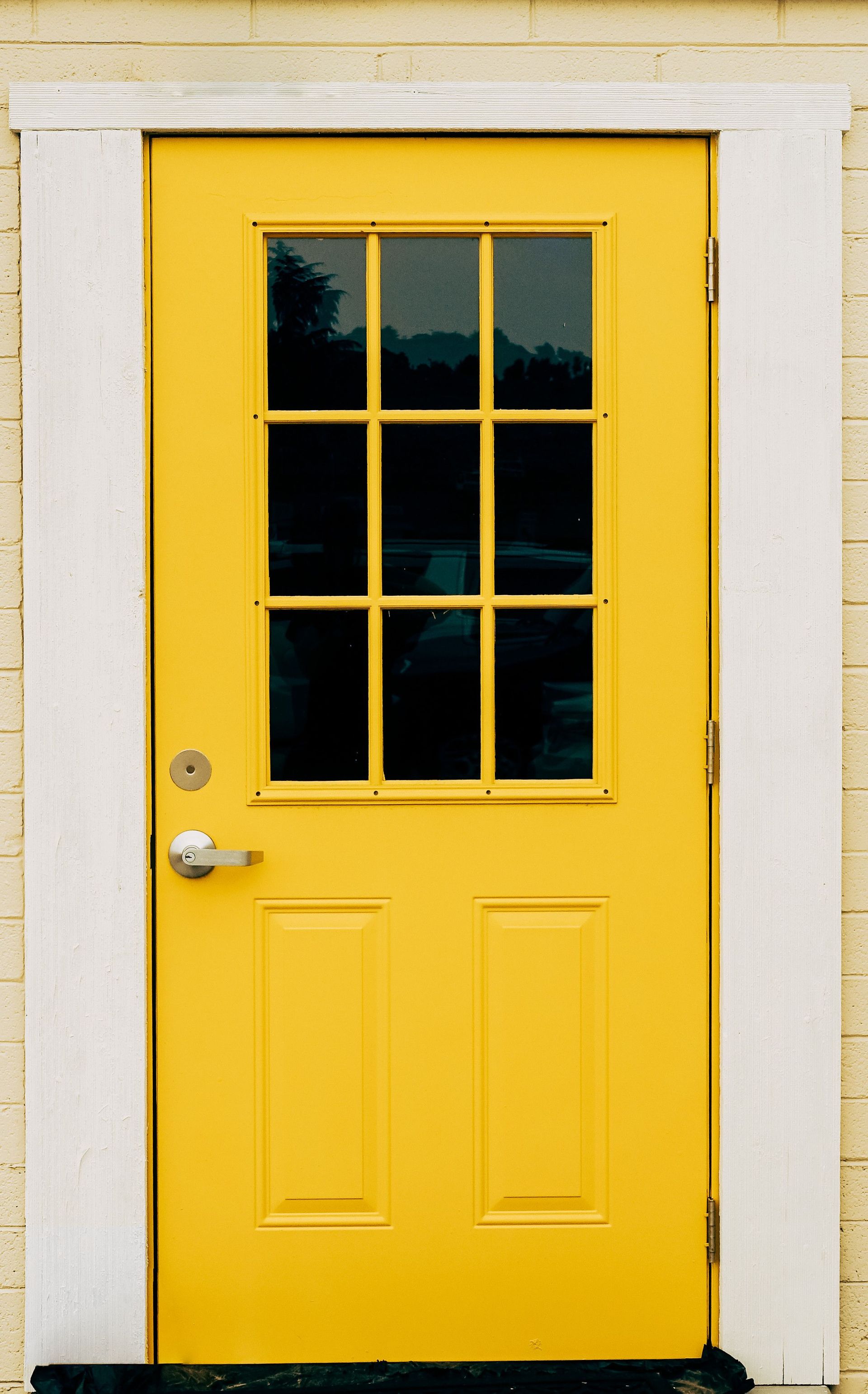 Bright yellow exterior door with glass panels and white trim in Payson, Arizona.